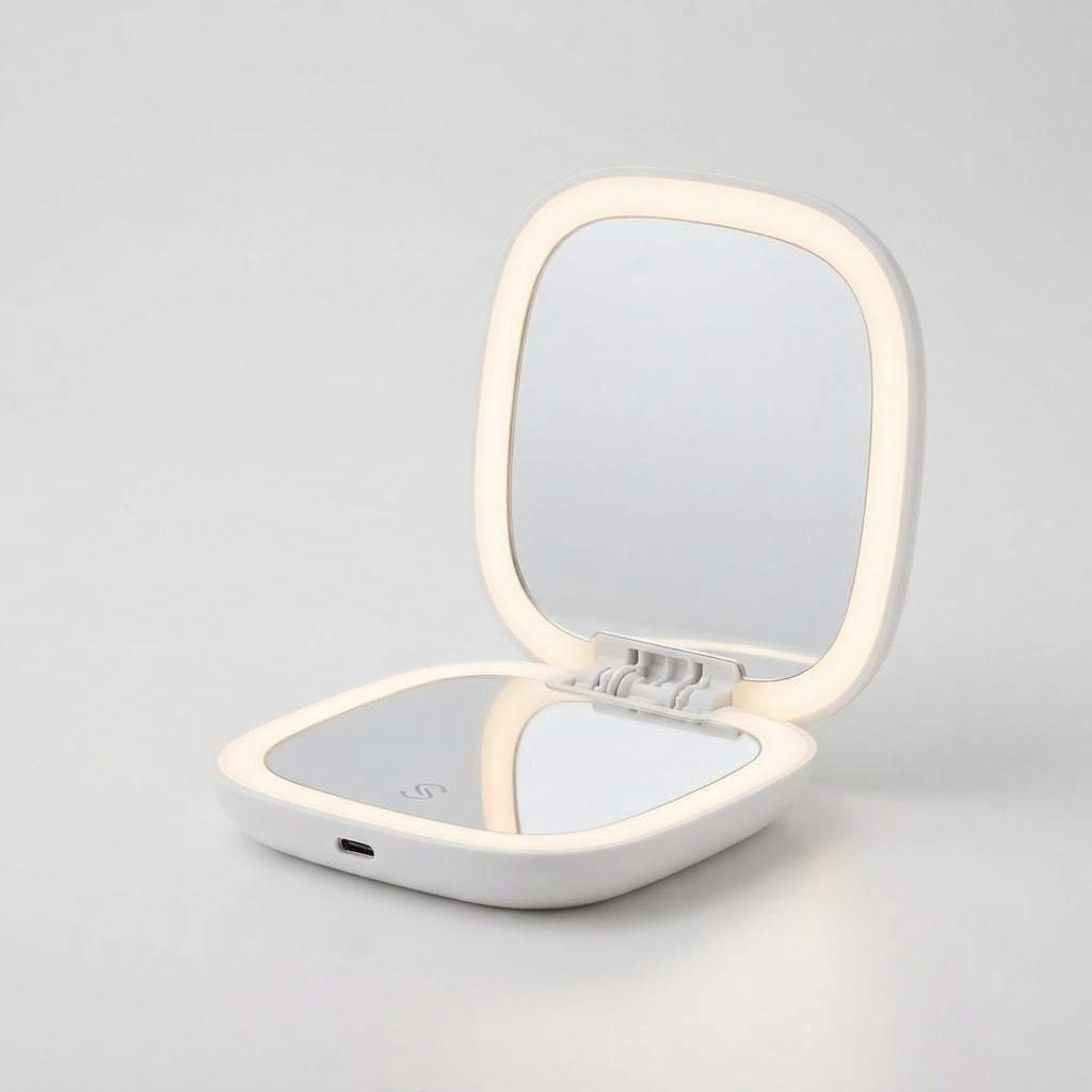 The folding travel mirror open on a white surface