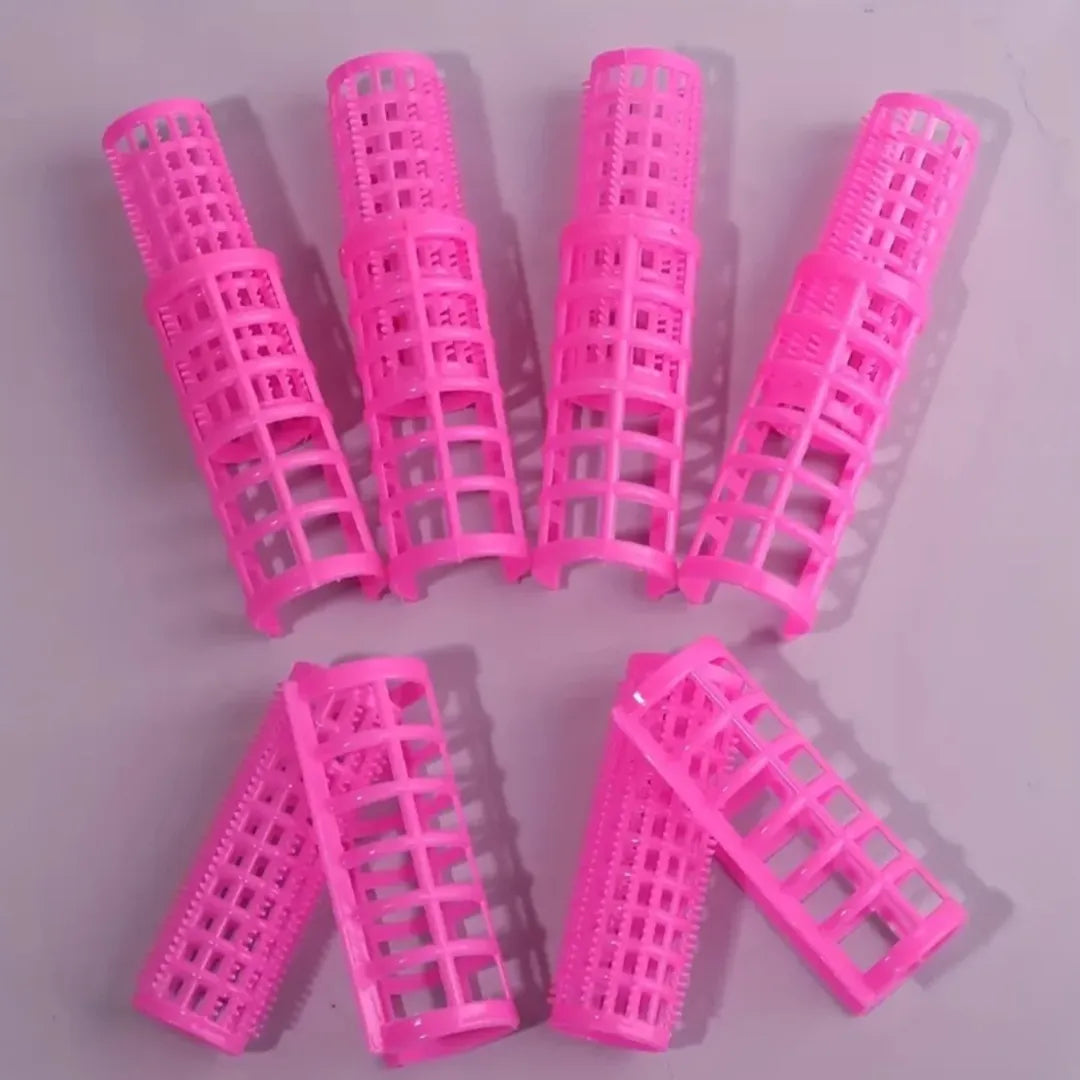 Twelve pink mesh hair rollers laid out in two rows