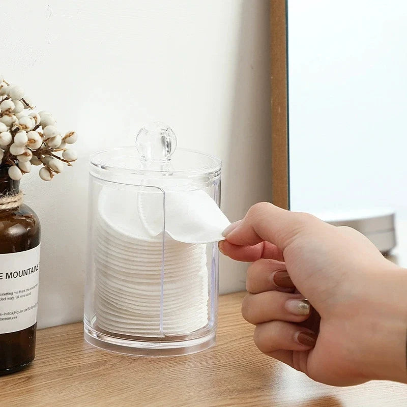 A hand taking a cotton pad from the jar
