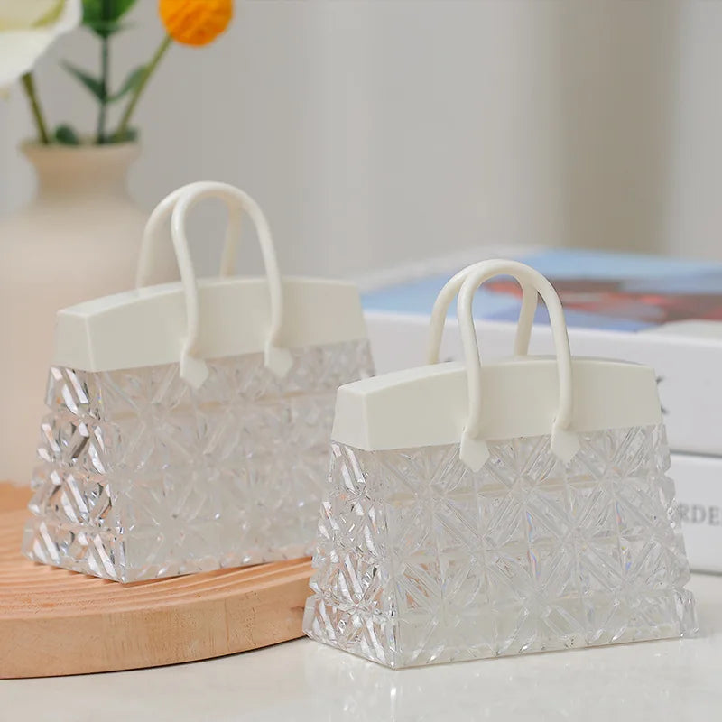 Two crystal handbag lamps, switched off, on a table
