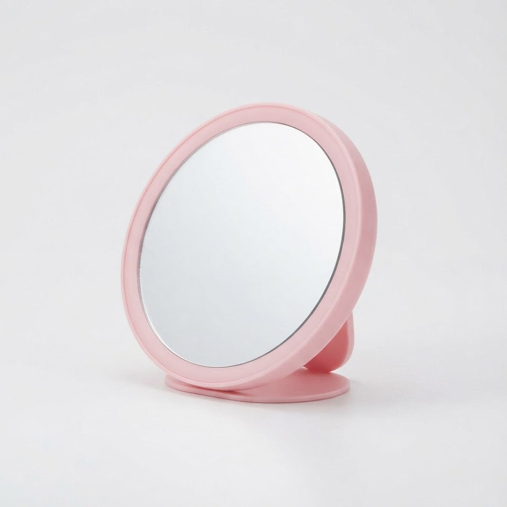Round pink makeup mirror on a stand