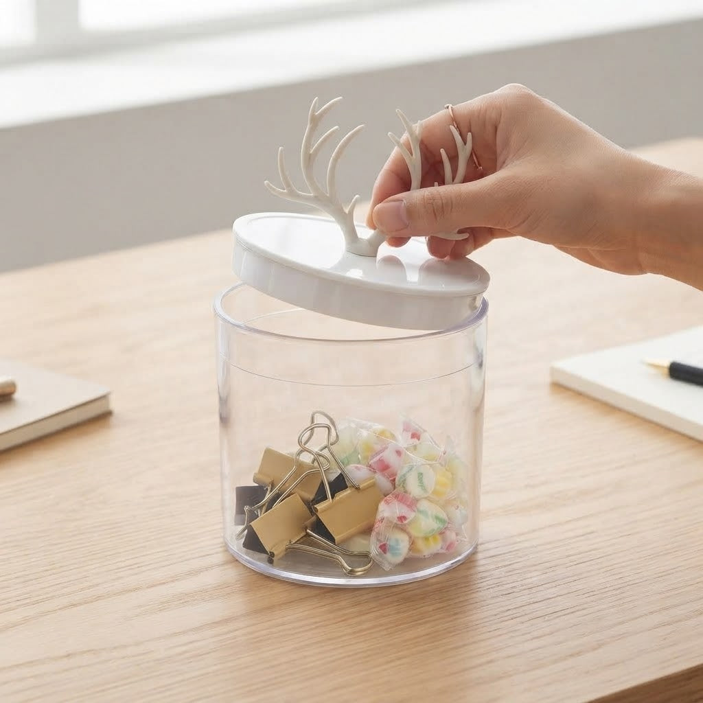 A hand lifting the antler lid off the jar