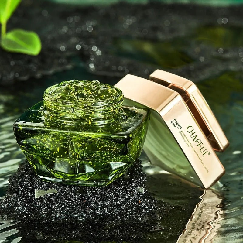 The jar open and tilted, its rose gold lid beside it, showing the green gel and its flecks.