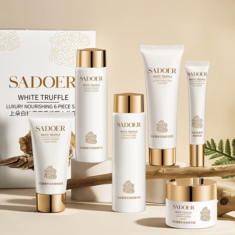 The White Truffle six-piece set with its box, on warm sand with driftwood and a fern.