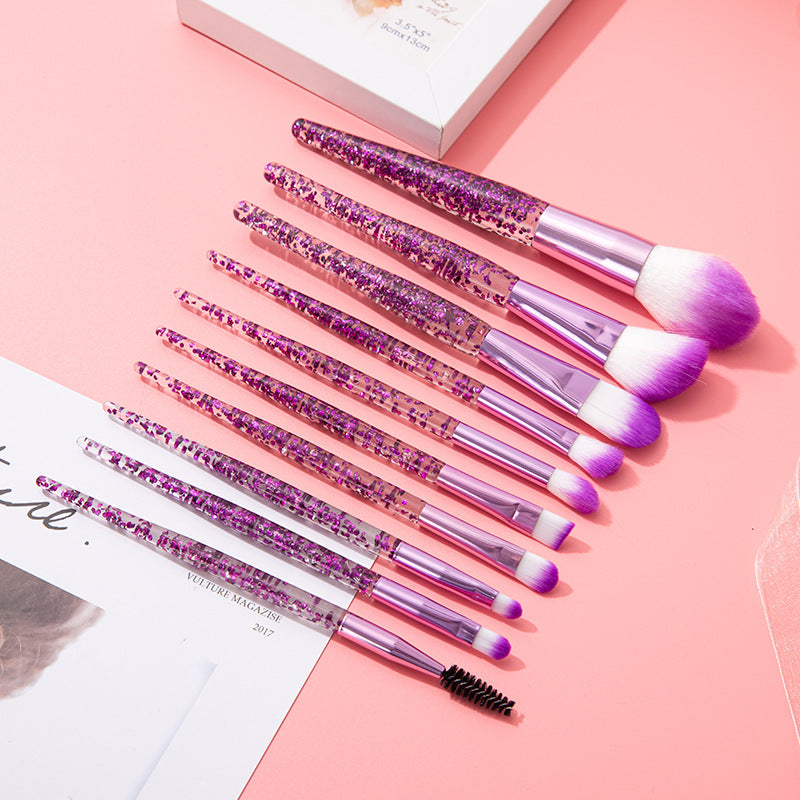 The purple glitter makeup brushes laid out on pink paper